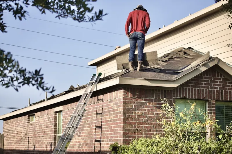 Professional roofer working on a residential roof in Airmont Acres